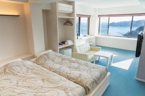 Atami-view Resort في أتامي: غرفة نوم بسرير وكرسي ونافذة