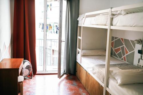 a room with three bunk beds with a window at LOFT APART & HOSTAL Group in Lloret de Mar