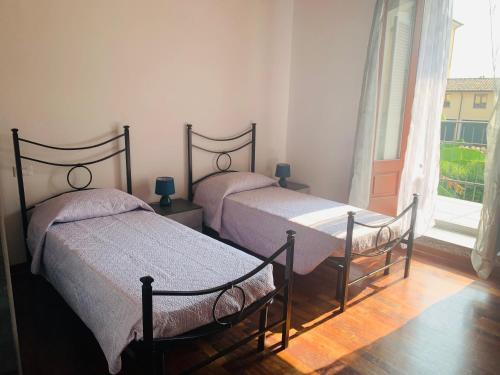 two beds in a room with a window at La Chiocciola in Sale