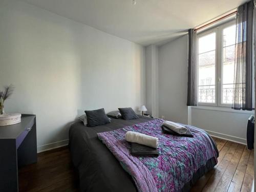 1 dormitorio con 1 cama con 2 toallas en Chez Tonio - Montereau, en Montereau-Fault-Yonne