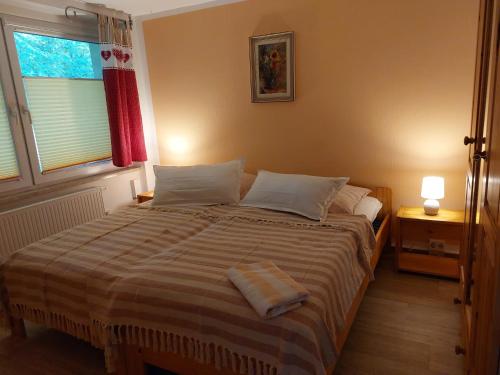 a bedroom with a large bed with a striped blanket at Waldesruh in Sallgast