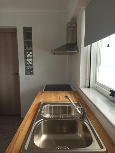 a kitchen with a stainless steel sink and a window at Sun Meets Sea in Athanion