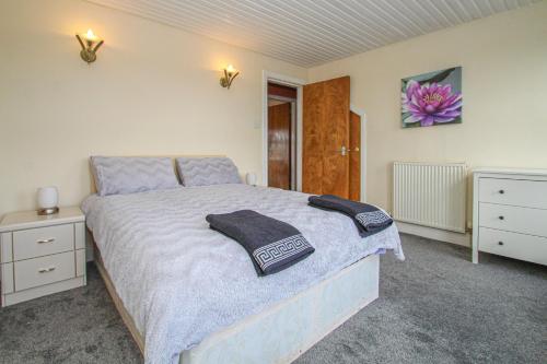 a bedroom with a bed with two towels on it at Tinto View Apartment in Carstairs