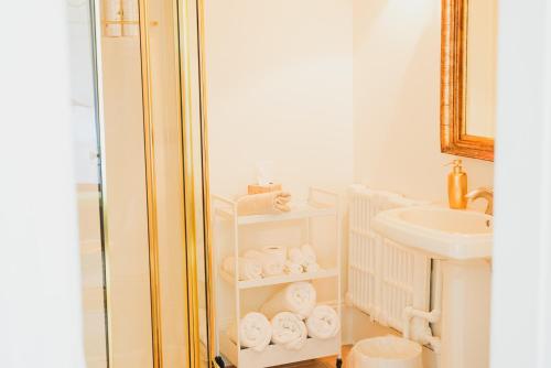 uma casa de banho com um lavatório e uma prateleira com toalhas em Bellview Luxury Suites em Baddeck