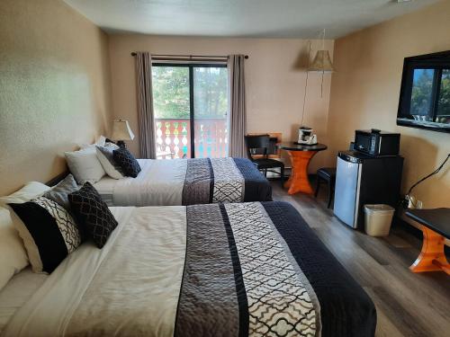 a hotel room with two beds and a window at Alpen Motel in Radium Hot Springs