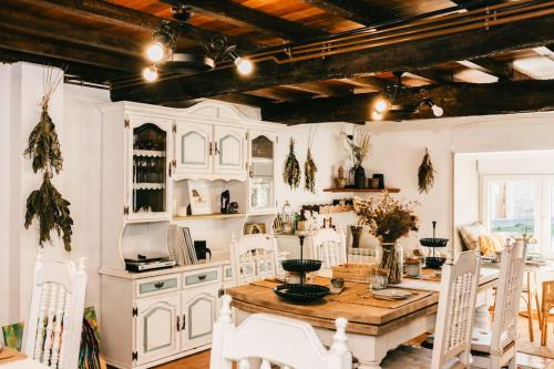 Una cocina con una mesa de madera y gabinetes blancos. en Casa do Cuco - Rural house, en Friol