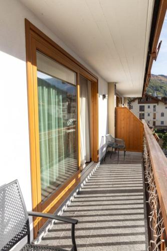 a balcony with a bench and a window on a building at Olimpia Hotel in Bormio