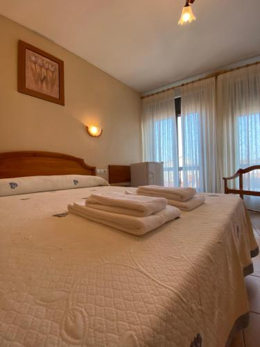 1 dormitorio con 2 camas y toallas. en Hostal Jose Mari, en Ciudad Rodrigo
