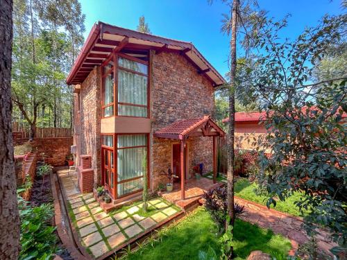 a brick house with a gazebo in a yard at Sereno Barn Eco Stay Chikmagalur in Chikmagalūr