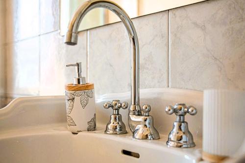 a sink with a faucet and two knobs on it at La Villa Bligny in Étretat