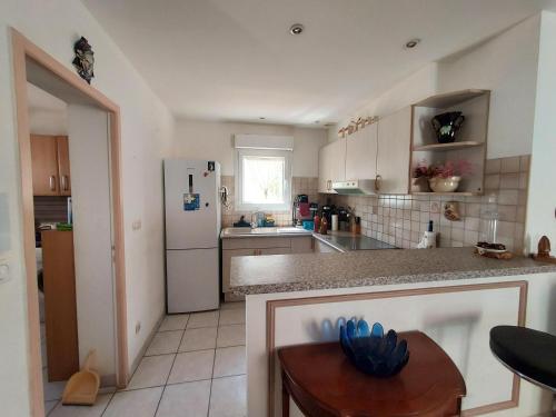 une cuisine avec un réfrigérateur blanc et une table dans l'établissement Sainte Marie la mer : Villa indépendante, plage à pied à 250 m, à Sainte-Marie-la-Mer
