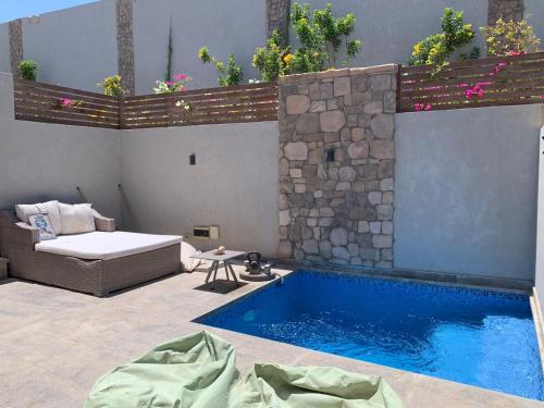a pool with a bed and a couch next to a swimming pool at Gouna 1 Bedroom Villa Private Pool & Patio Up to 5 Persons Bali in Hurghada