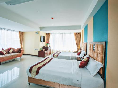 a large bedroom with two beds and a couch at Darling Harbour Residence - South Pattaya in Pattaya South