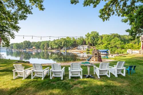 a group of chairs and a table in the grass next to a lake at Thunderbird Resort Condo in Wisconsin Dells