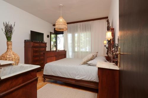a bedroom with a bed and a television and a window at Zen Garden Sew View Apartment in Trogir
