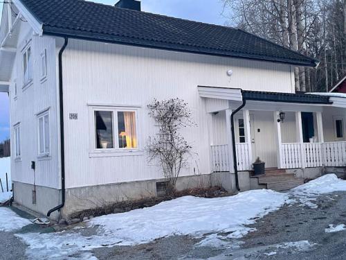 una casa blanca con nieve delante en Koselig gammelt hus på gård 