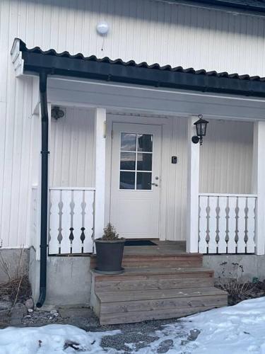 a house with a porch with a potted plant on it at Koselig gammelt hus på gård in Forberg