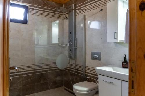 a bathroom with a shower and a toilet and a sink at Rüya Villen Park in Cıralı