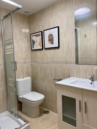 een badkamer met een toilet, een wastafel en een spiegel bij Andainas Apartamentos Turísticos F in Milladoiro