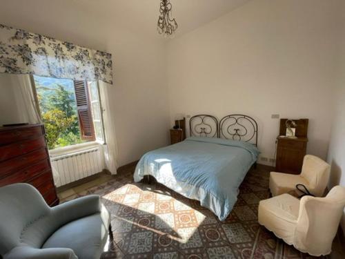 a bedroom with a bed and two chairs and a window at Villa Cinque Terre in Beverino