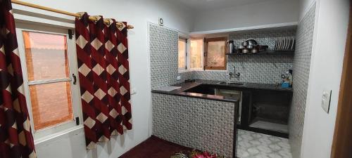 uma cozinha com um lavatório e uma bancada em THE CLOVER Home Stay em Srinagar