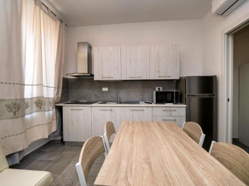 a kitchen with a table with chairs and a refrigerator at Iside Accommodations in Olbia