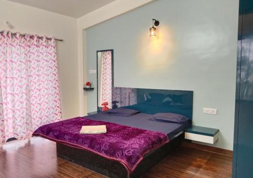 ein Schlafzimmer mit einem Bett mit einer lila Decke in der Unterkunft Bluebeli Mountain Villa By Holiday Villass in Mahabaleshwar