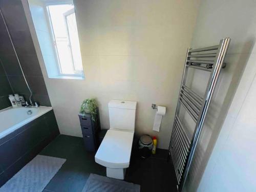 y baño con aseo, lavabo y bañera. en Modern cosy house /free parking for two cars/ 3 minutes walk to the underground en Londres