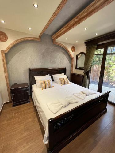 a bedroom with a large bed with white sheets and pillows at Villa Ioanna Oxylithos, Kymi in Oxílithos