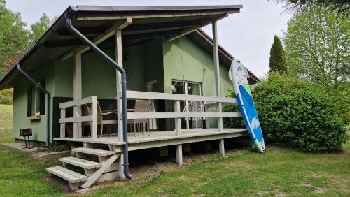 a small green house with a surfboard next to it at Zielone Wzgórza in Bytów