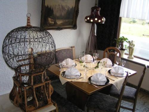 a dining room table with a bird cage on it at Hotel Kalenborner Höhe in Kalenborn