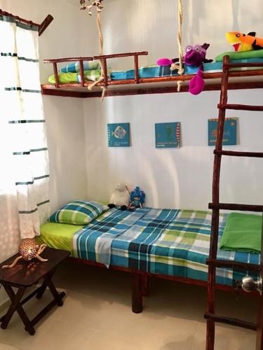 a bedroom with a bunk bed and a ladder at Casita Sac-Nicté in Mahahual