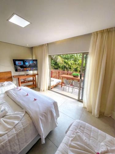 a bedroom with a bed and a view of a patio at Flat Completo Pipa no condominio do lle de Pipa in Pipa