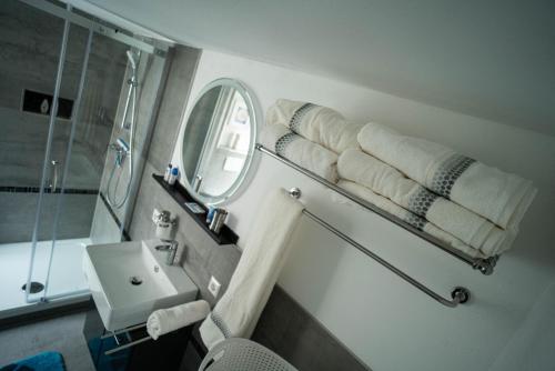 een badkamer met een wastafel, een spiegel en handdoeken bij Barockes Refugium I 10 Minuten zum Europa-Park in Ettenheim
