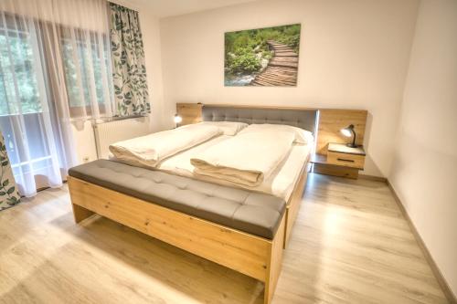 a bedroom with a large bed with a wooden frame at Haus Oberautal in Achenkirch