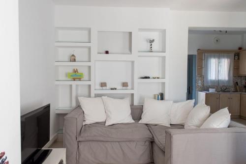 a living room with a gray couch with white pillows at Monolithos Pool Villa by the Beach in Monolithos