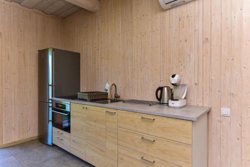 a kitchen with a stainless steel refrigerator and wooden cabinets at Duriu sodyba in Molėtai
