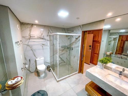 a bathroom with a shower and a toilet and a sink at Flat Completo Pipa no condominio do lle de Pipa in Pipa