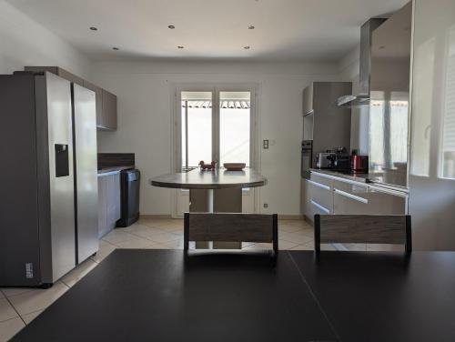- une cuisine avec une table et deux chaises dans l'établissement Maison au cœur des Alpilles, à Mouriès