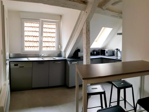 une cuisine avec une table et deux tabourets dans l'établissement Duplex au centre avec parking - L'étoile, à Obernai