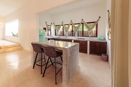a kitchen with a table and chairs in a room at Mi Kasa Tu Kasa Bacalar by Nah Hotels in Bacalar