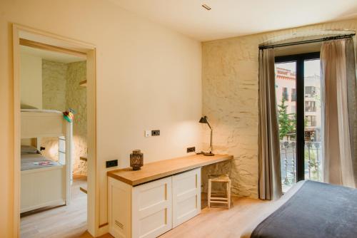 a bedroom with a desk and a bed and a window at Casa Indiana Hotel Boutique in Blanes