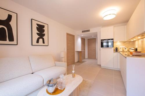 un salon avec un canapé blanc et une table dans l'établissement OSCAR, appartement de standing, à Saint-Tropez
