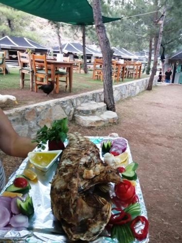 una mesa de comida con una gran pieza de carne en DURUSU ÇİFTLİKEVLERİ, en Datça