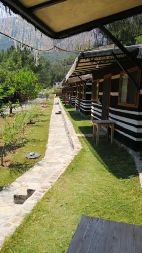 un bâtiment avec une passerelle à côté d'un champ d'herbe dans l'établissement DURUSU ÇİFTLİKEVLERİ, à Datça