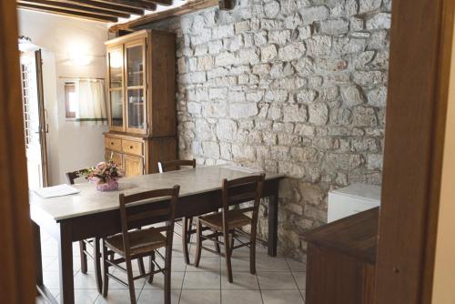 comedor con mesa, sillas y pared de piedra en Borgo Giusto Tuscany, en Diecimo