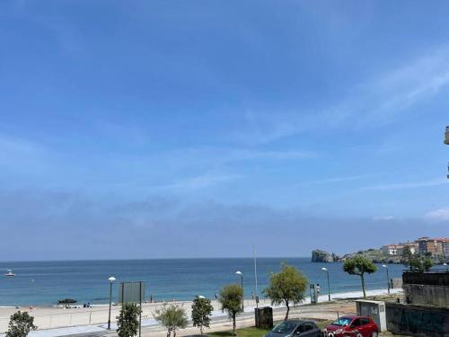 uma vista para a praia e para o oceano com carros estacionados em Ostende Beach View apartment em Castro-Urdiales