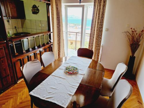 ein Esszimmer mit einem Tisch, Stühlen und einem Fenster in der Unterkunft Guest House Sombrero 2 in Senj
