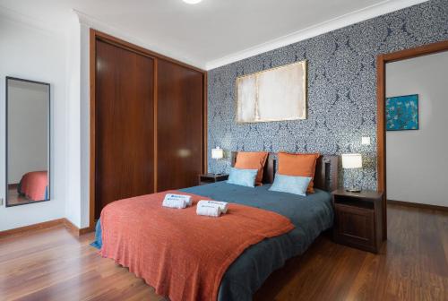 - une chambre avec un lit et 2 serviettes dans l'établissement Spacious Duplex House - Jacuzzi & Terrace, à Porto