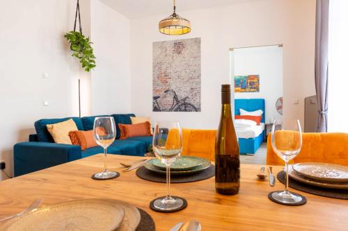 a table with wine glasses and a bottle on it at Soulscape Apartments DELUXE Zwickau CityCenter mit TG-Stellplatz und Magenta-TV in Zwickau